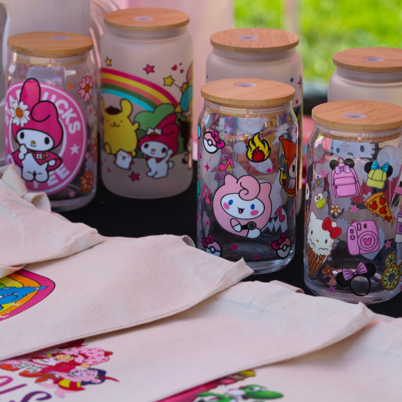 Colorful handmade tumblers and accessories displayed at a festival vendor table.