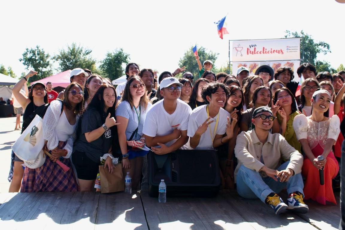 A large group of young people, artists, and community members smiling together at the Bayanihan Festival.